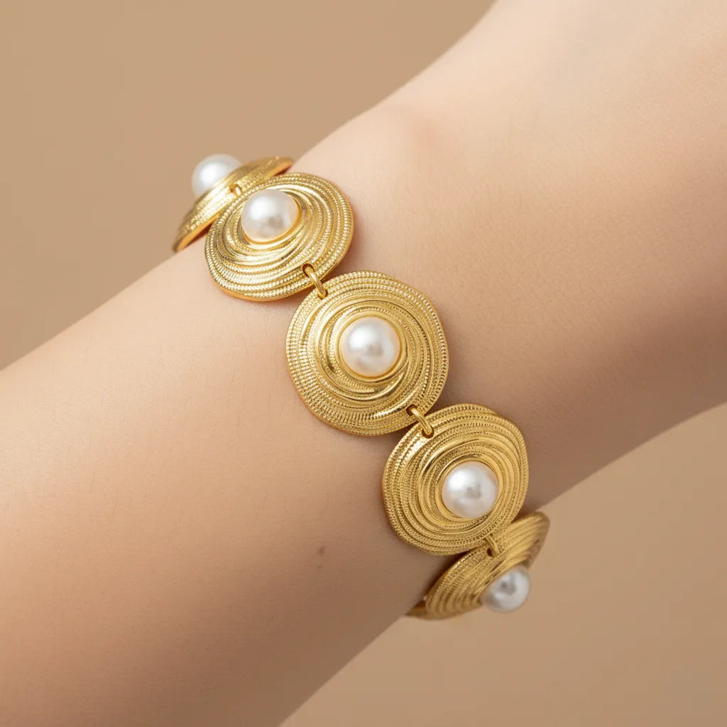 An artistic, moody shot of The Hera Bracelet on a model's wrist against a dark background, highlighting its brilliant gold shine and regal form.