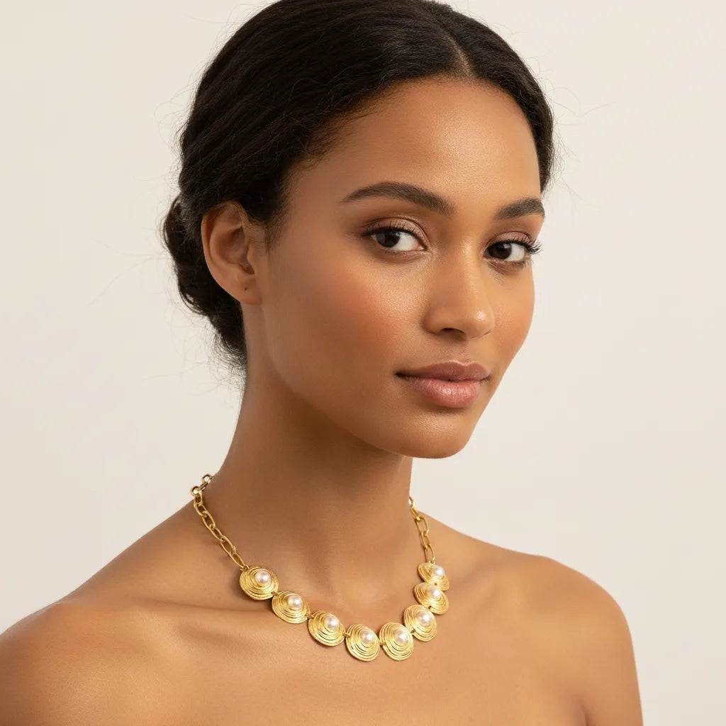 A beautiful model wearing The Hera Necklace with an off-the-shoulder top, highlighting its majestic presence and how it sits elegantly on the collarbone.
