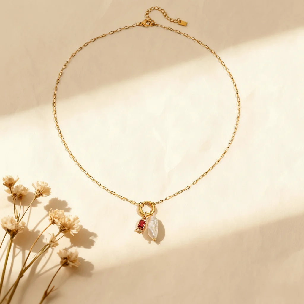 The January birthstone (garnet red) version of The Astoria Necklace, featuring a deep red gem that contrasts beautifully with the gold chain.