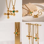 Aesthetic product photography of gold cross necklaces with green and brown stones on jewelry stand.