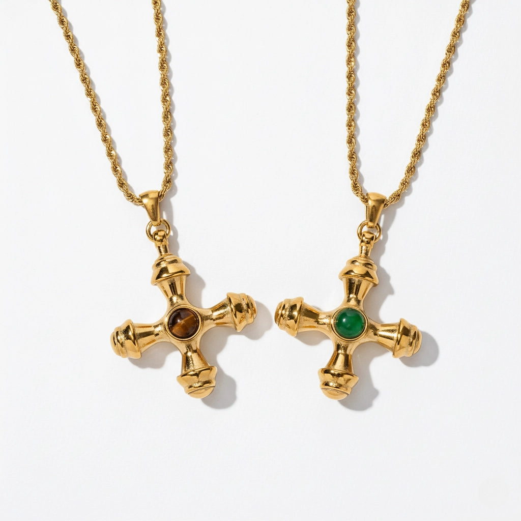 A detailed studio shot of The Jupiter Necklace by Luminova, showcasing both the Tiger Eye and Green Agate gemstone options in the vintage-style gold cross pendant.