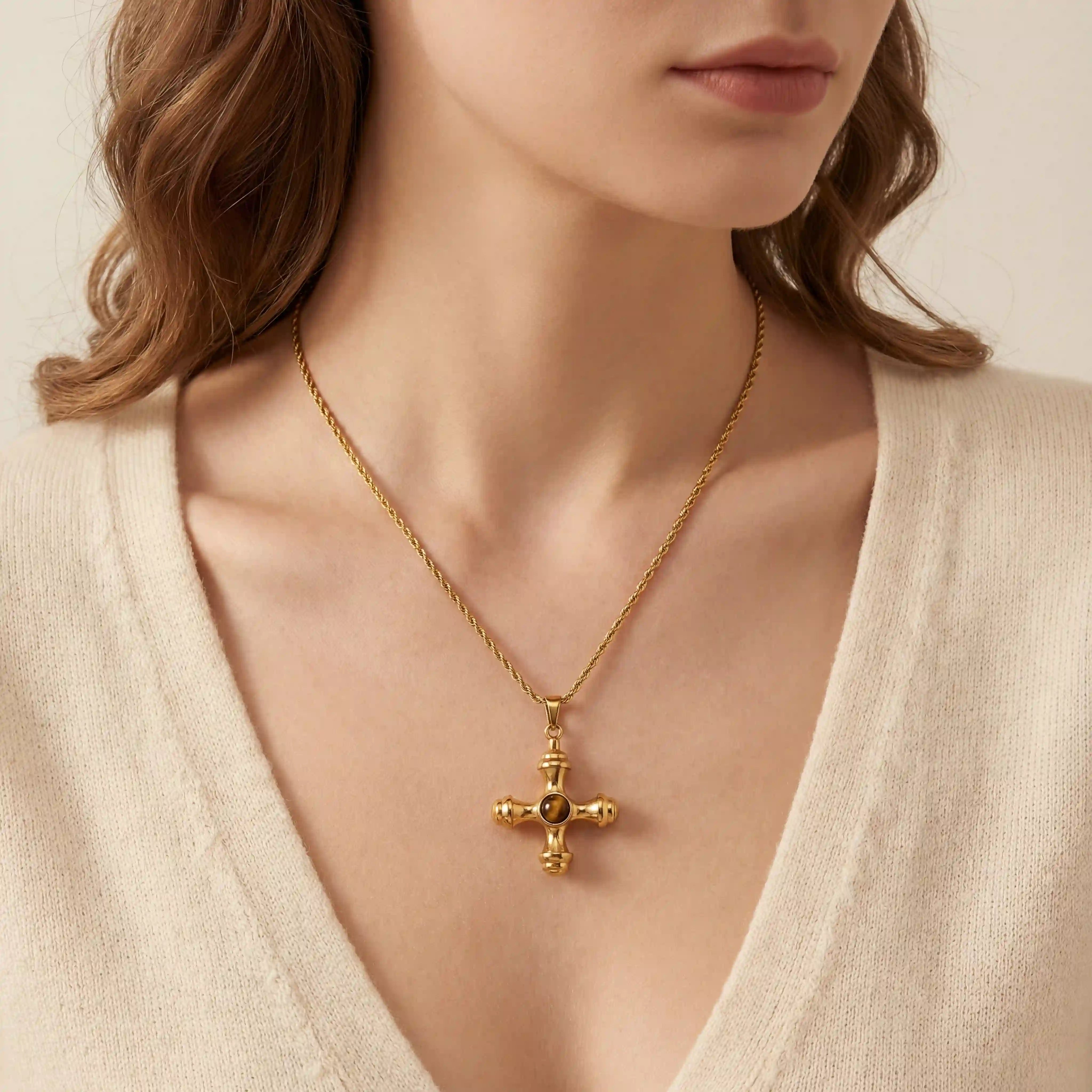 Close up of woman wearing gold Jupiter necklace with vintage cross pendant and amber stone. Main image