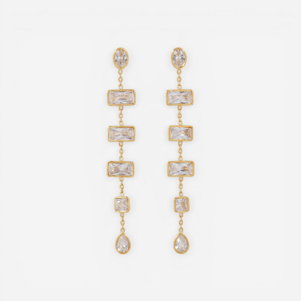 Pair of long gold linear earrings with rectangular and teardrop cubic zirconia stones.