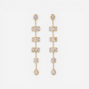 Pair of long gold linear earrings with rectangular and teardrop cubic zirconia stones.