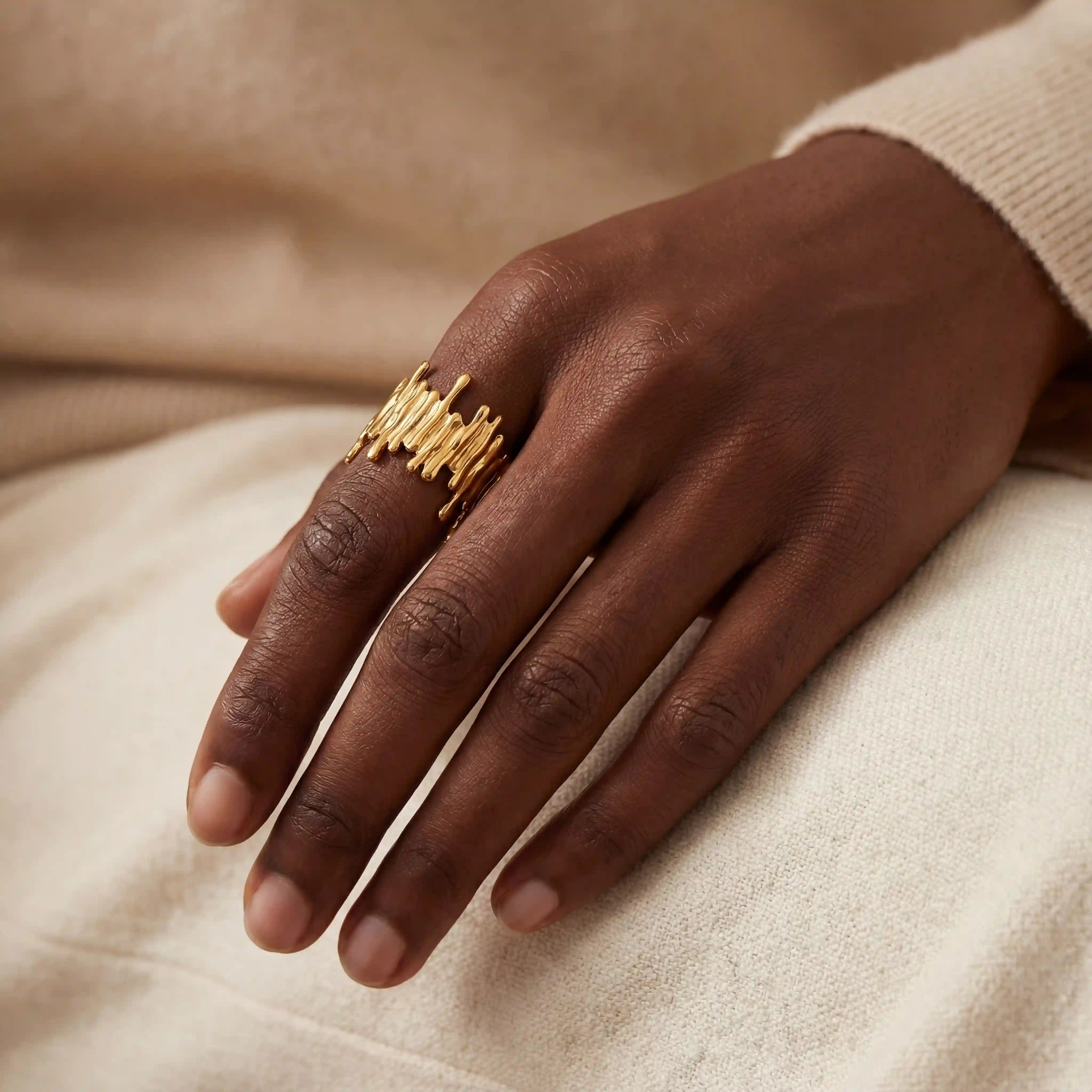 Dark skin model styling Midas textured gold statement ring organic drip design.