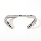 Silver sculptural wave bangle bracelet high polish stainless steel modern jewelry.