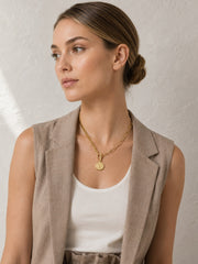 Mixed chain gold necklace with coin charm shown on model