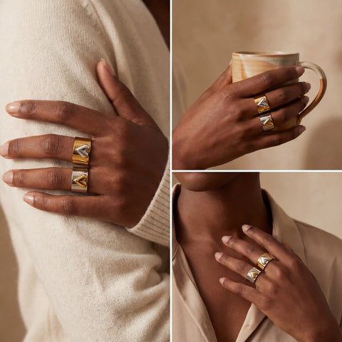 Model with dark skin wearing chunky two tone heart rings fashion jewelry.
