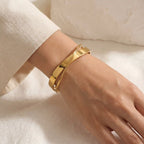 Woman wearing gold crossover bangle with beige sweater minimalist autumn style.