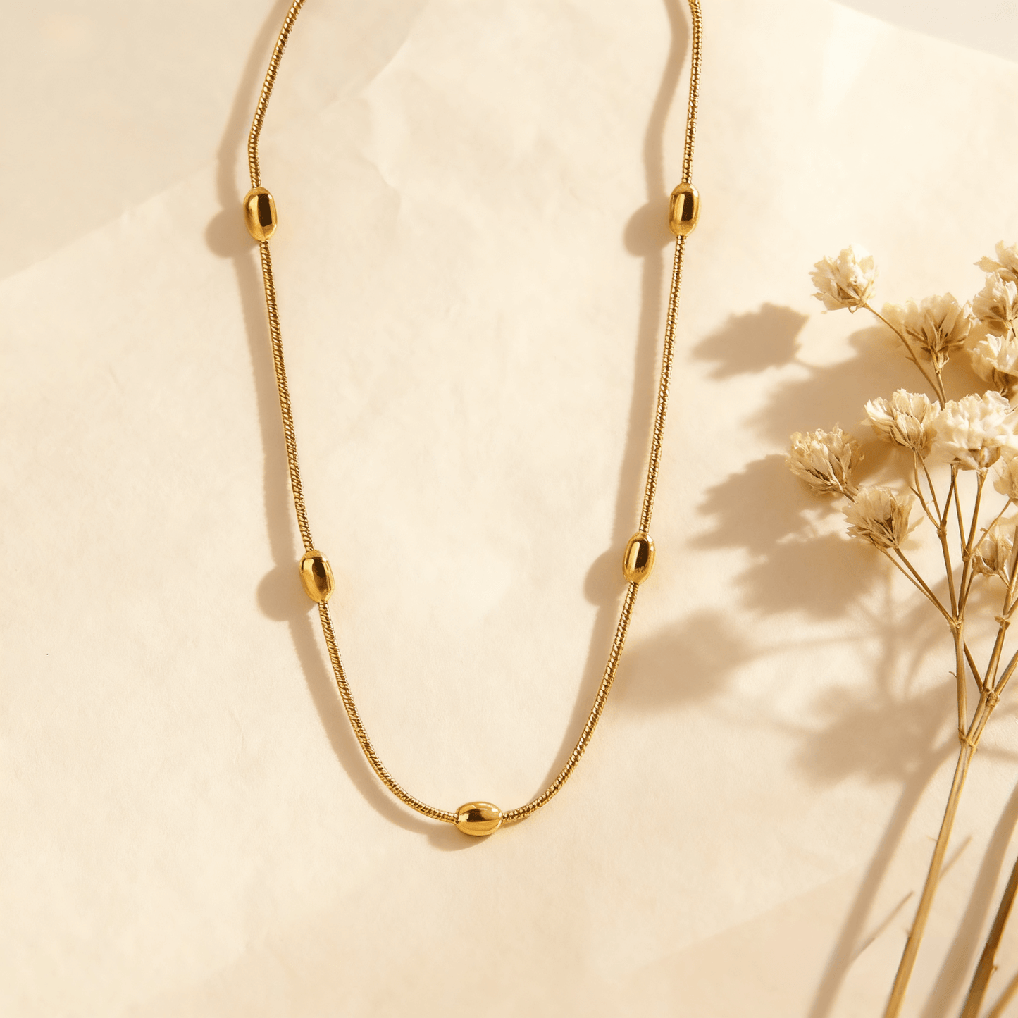 Luminova Dainty Beaded Gold Chain Necklace isolated on a white gold background, showcasing the textured bead design.