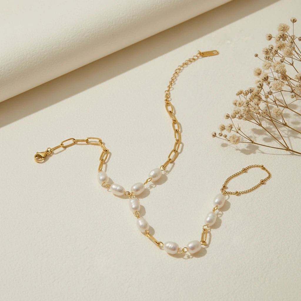 An artistic flat lay of The Nereid Hand Chain laid out in a graceful S-curve, styled with delicate dried flowers to highlight its romantic, bohemian feel.