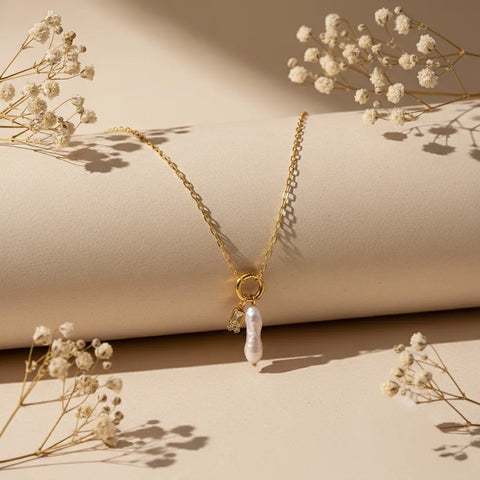 The Astoria Necklace for November, featuring a warm and sunny citrine yellow birthstone charm, styled artfully with dried flowers.