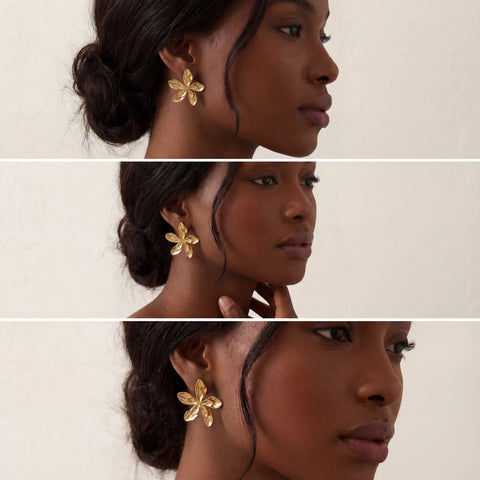 Dark skin model styling sculptural gold flower studs vintage art vibe.