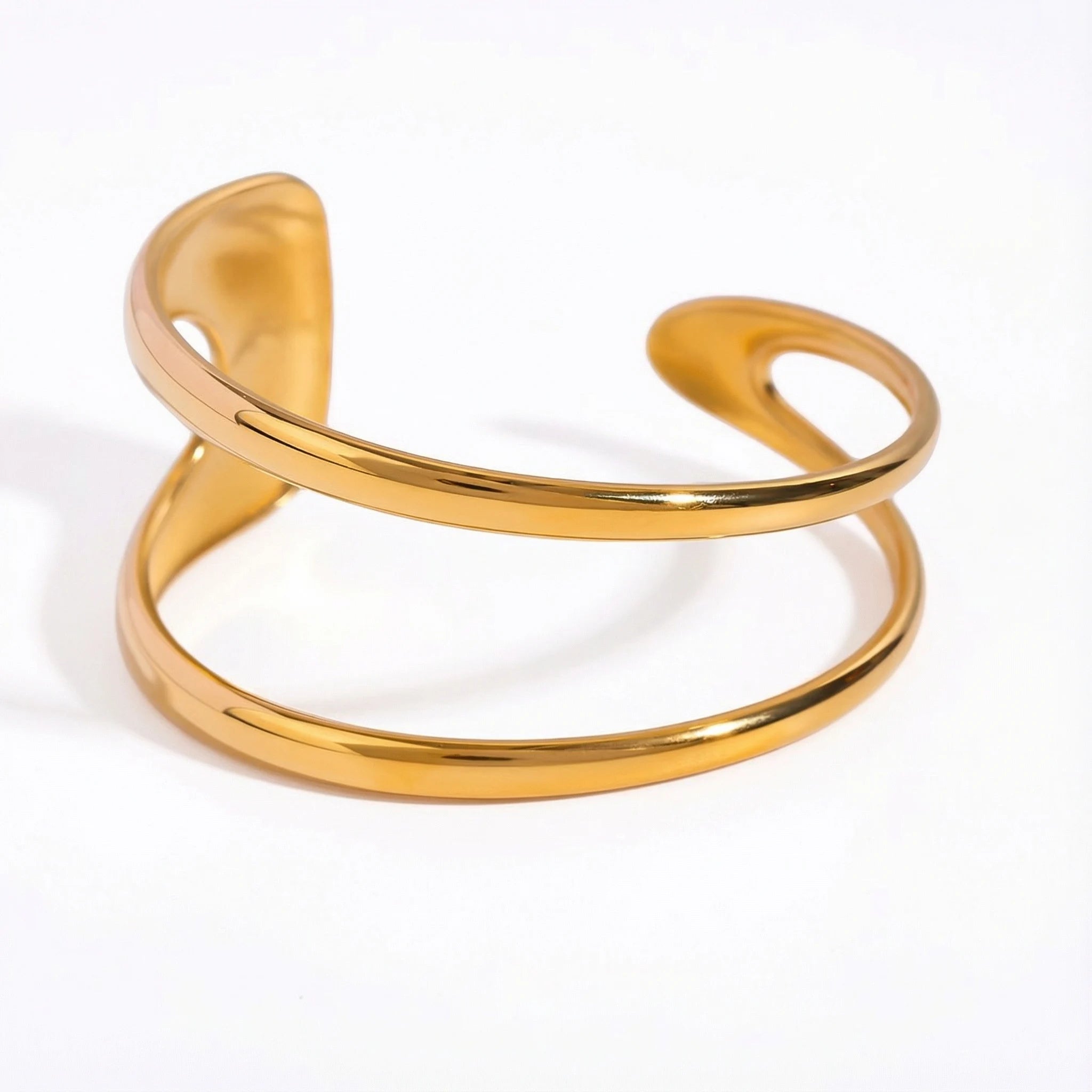 Organic double-wave open cuff bracelet gold stainless steel sculptural design.