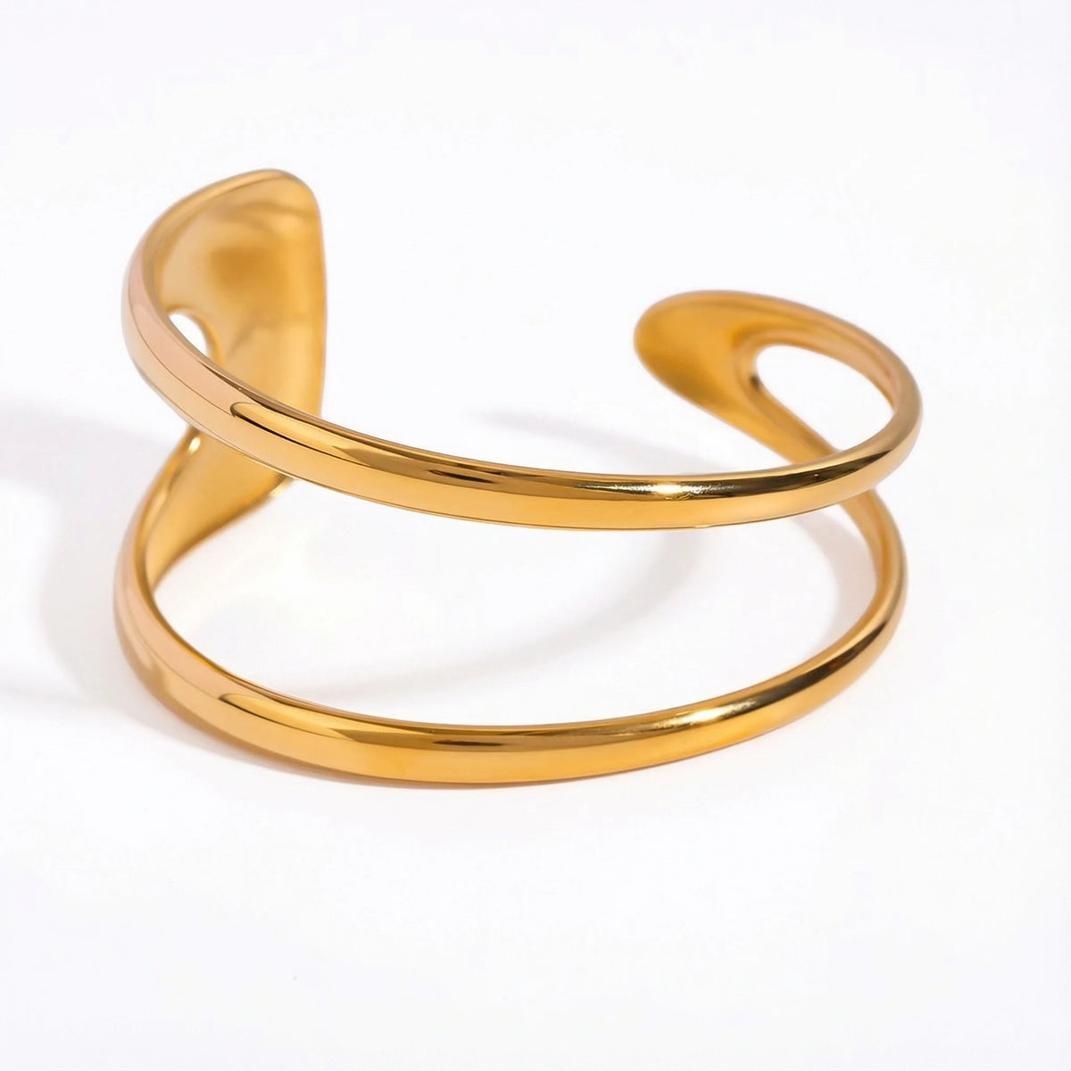 Organic double-wave open cuff bracelet gold stainless steel sculptural design.
