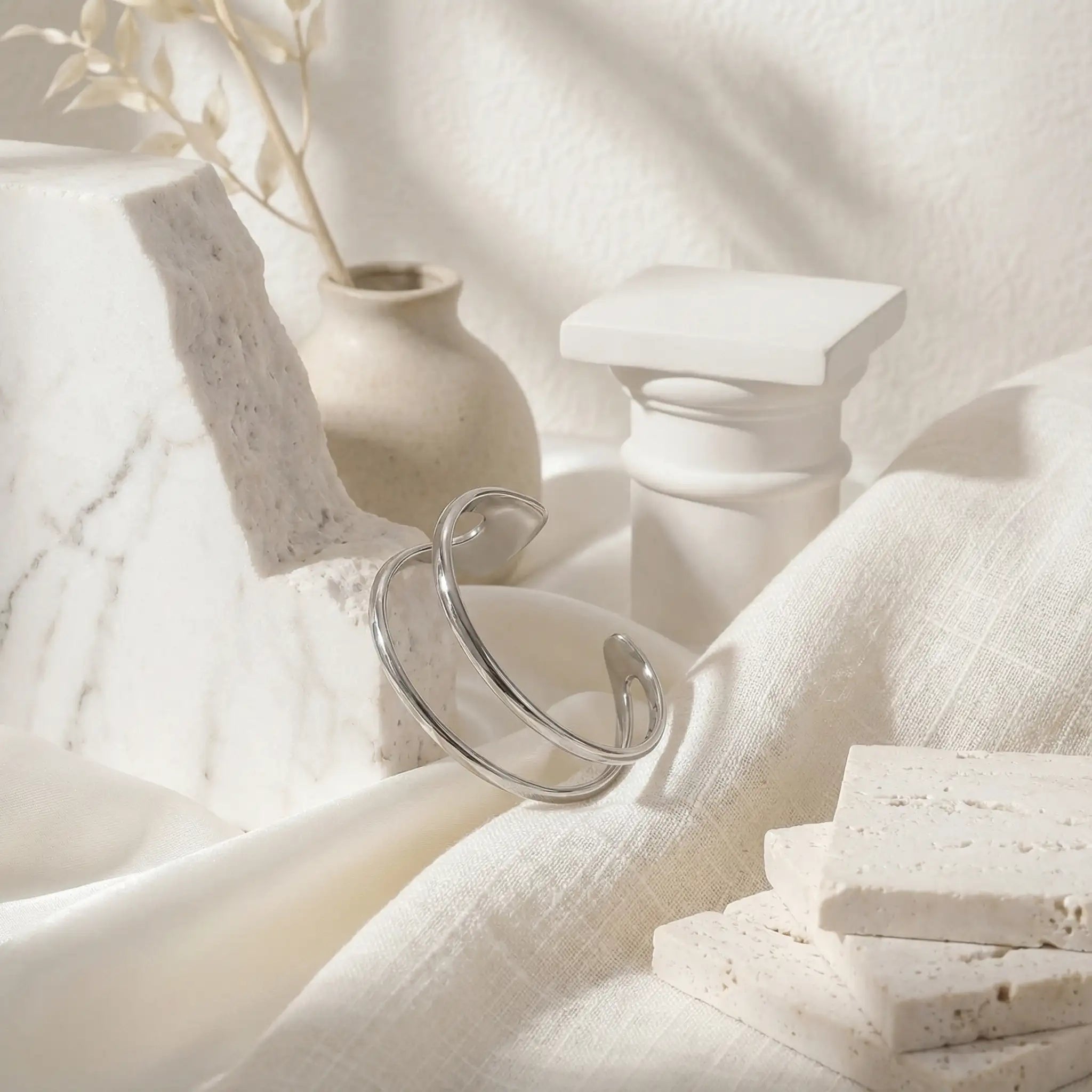 Mood board of silver sculptural cuff bracelet minimalist jewelry photography.