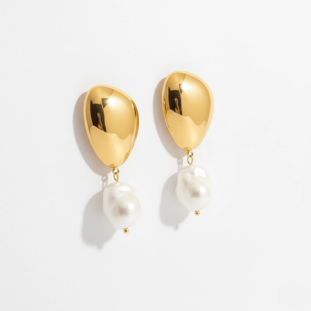 Pair of sculptural gold and white pearl drop earrings, waterproof stainless steel jewelry.