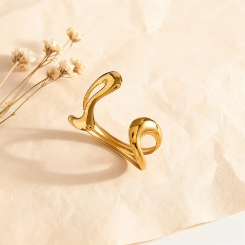 The Pythia Cuff styled with delicate dried flowers, highlighting the fluid, molten-like curves of the open-ended gold serpent bracelet.