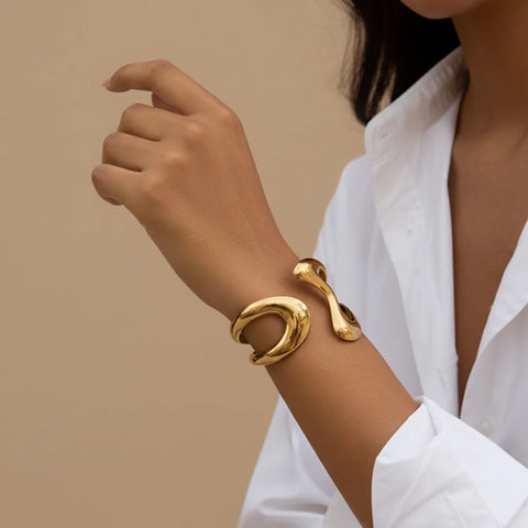 A close-up of a model's wrist, wearing The Pythia Cuff over a classic white shirt sleeve, demonstrating its power as a statement accessory.