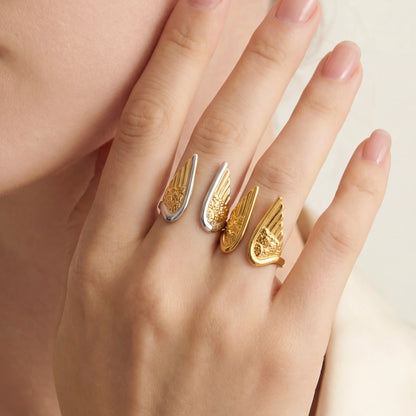 Close up of woman wearing two Seraphina angel wing rings in gold and two-tone mixed metal styles.
