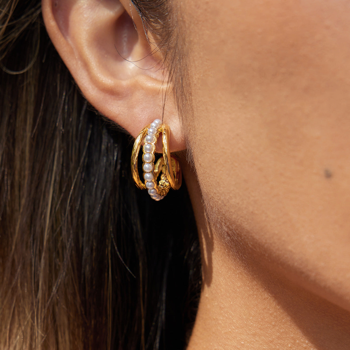 An elegant model wearing The Siren Hoops, showing how they provide a powerful yet classic statement from a slightly different angle.