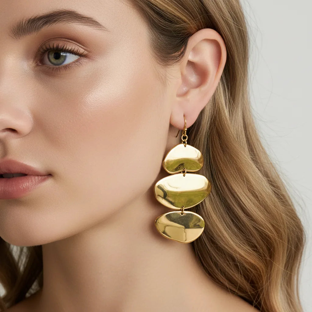 A beautiful side profile of a model, her hair swept back to feature The Thalia Earrings, showing how they catch the light with every movement.