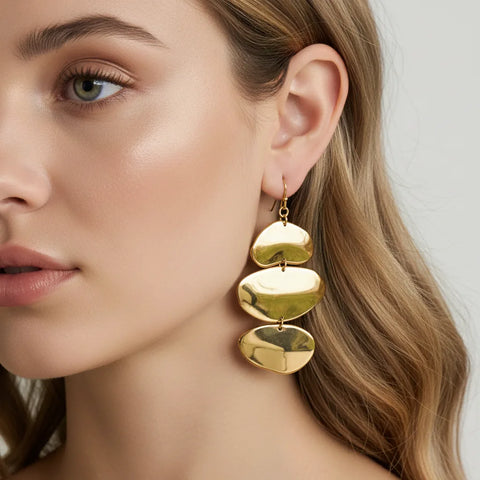 A beautiful side profile of a model, her hair swept back to feature The Thalia Earrings, showing how they catch the light with every movement.