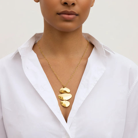 A model wearing The Thalia Necklace with a classic white shirt, demonstrating its power to elevate a simple, minimalist outfit into a fashion statement.