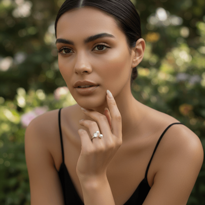 A model's hand gently holding a glass of white wine at a dinner party. The Celestial Ring sparkles under the ambient light, demonstrating its elegance as a perfect accessory for special occasions.