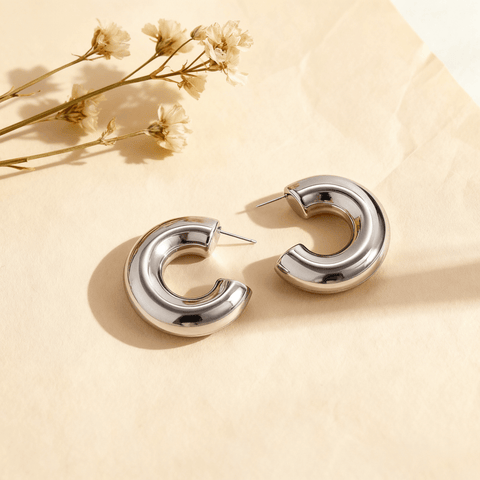 Detail shot of the chunky silver Cloud Hoops, highlighting their smooth, polished surface and C-shape design.