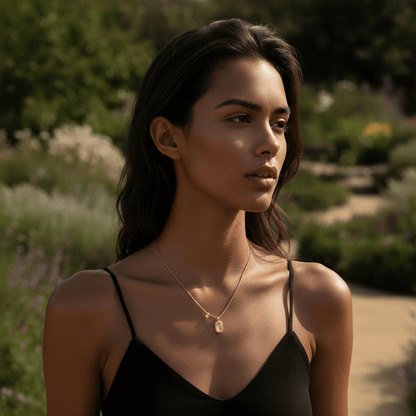 A model's neck is adorned with a layered necklace stack. The Signature Necklace serves as the shortest, foundational layer, paired with a longer, simple gold chain, demonstrating its versatility for stacking.