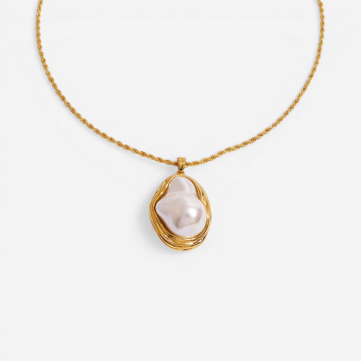 A detailed studio shot of The Theia Necklace by Luminova, showcasing the unique baroque pearl in its sculptural gold pendant on a rope chain, styled with dried flowers.
