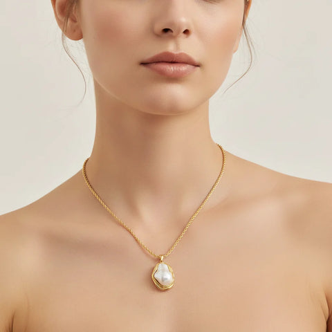 A beautiful close-up of The Theia Necklace on a model's collarbone, highlighting the one-of-a-kind pearl's luster against her skin.