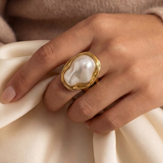 Close-up of a woman's hand wearing The Theia Ring on the index finger, showing how the bold, artistic piece looks against the skin."