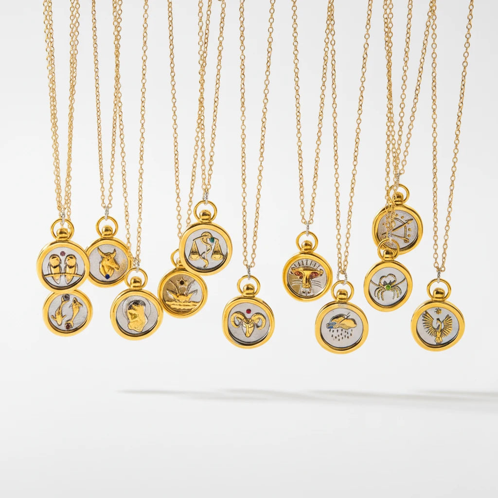 Collection of hanging two-tone zodiac coin necklaces mixed metal gold and silver pendants.