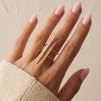 Close up of woman wearing gold urban minimal double-bar ring geometric design on middle finger.