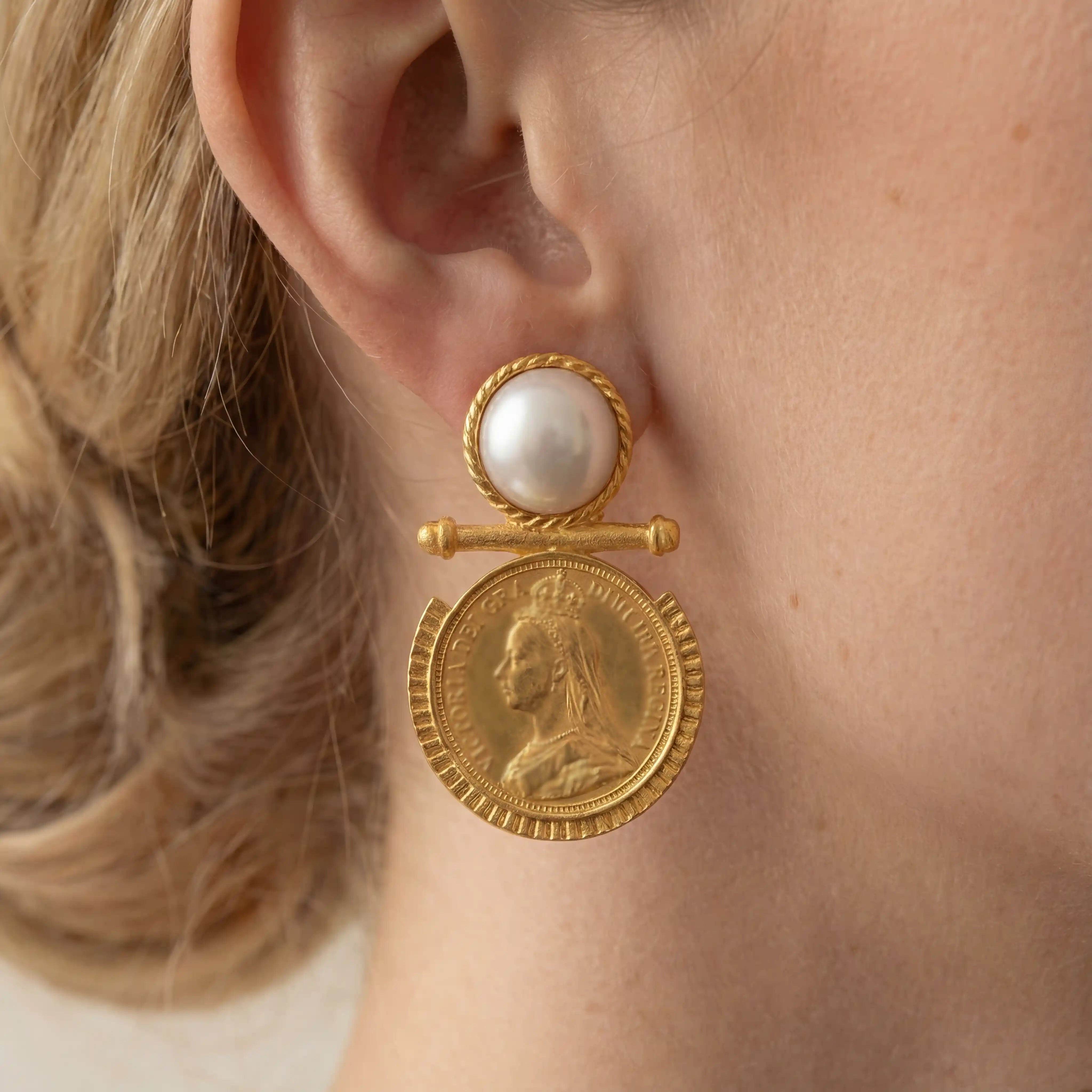Close up of gold coin earring with pearl stud vintage baroque style jewelry on woman. Main image