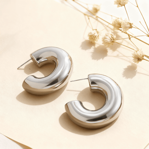 Detail shot of the chunky silver Cloud Hoops, highlighting their smooth, polished surface and C-shape design.
