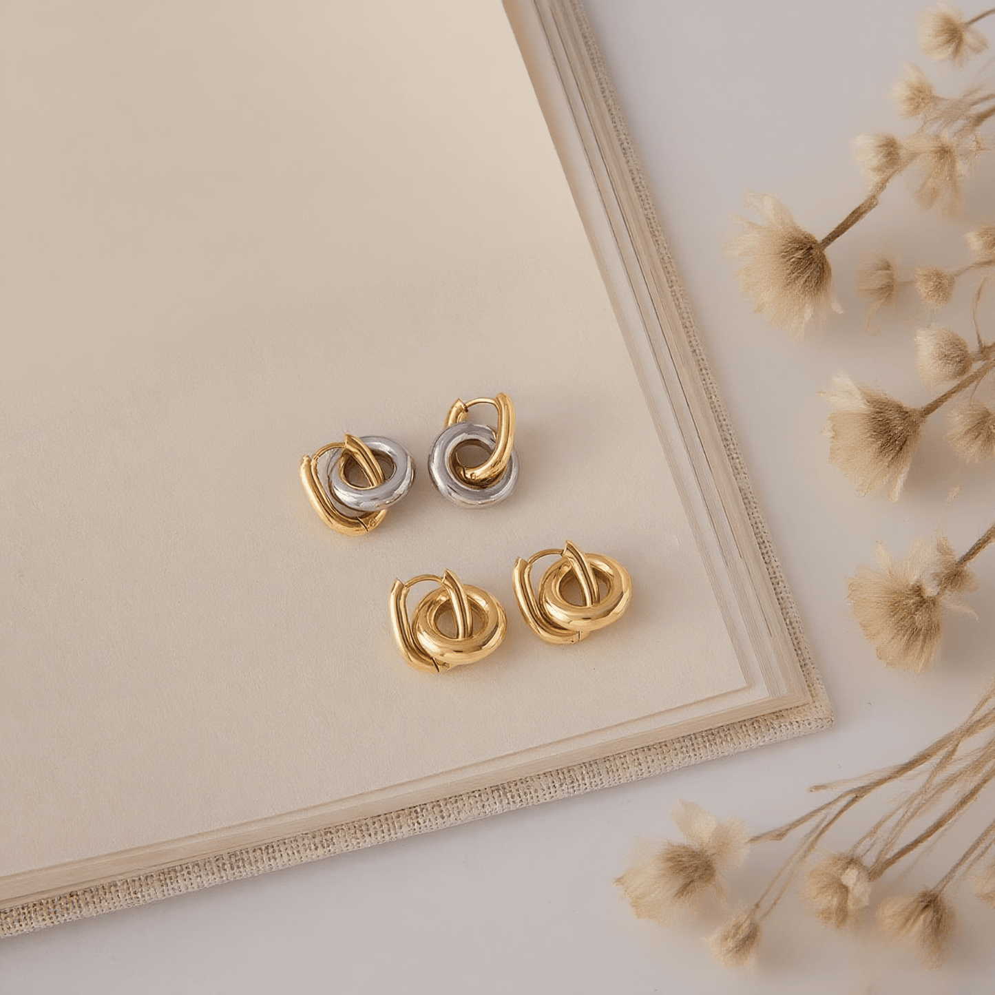 Close-up detail of the 3D twist knot and luxurious gold plating on Luminova's hoop earrings.