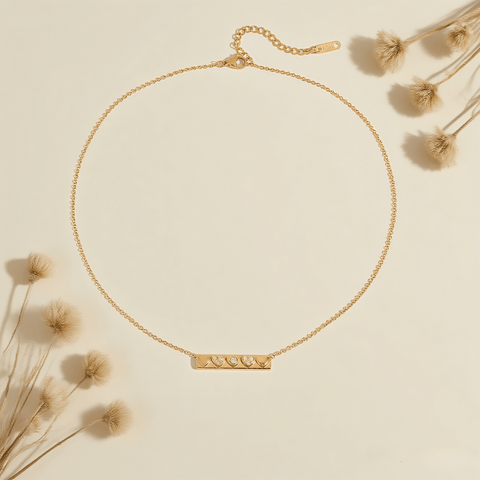 Heartline Bar Necklace — gold bar pendant with heart-shape detailing and stones, romantic and sleek.