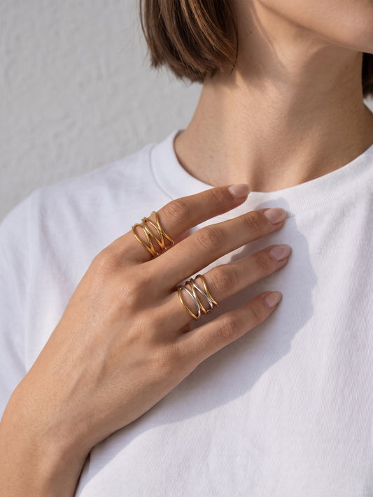 Ariadne Ring worn on the hand, showing its layered crossover band design