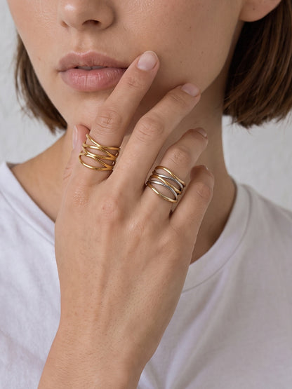 Ariadne Ring worn on the finger, highlighting the wide crossover band profile