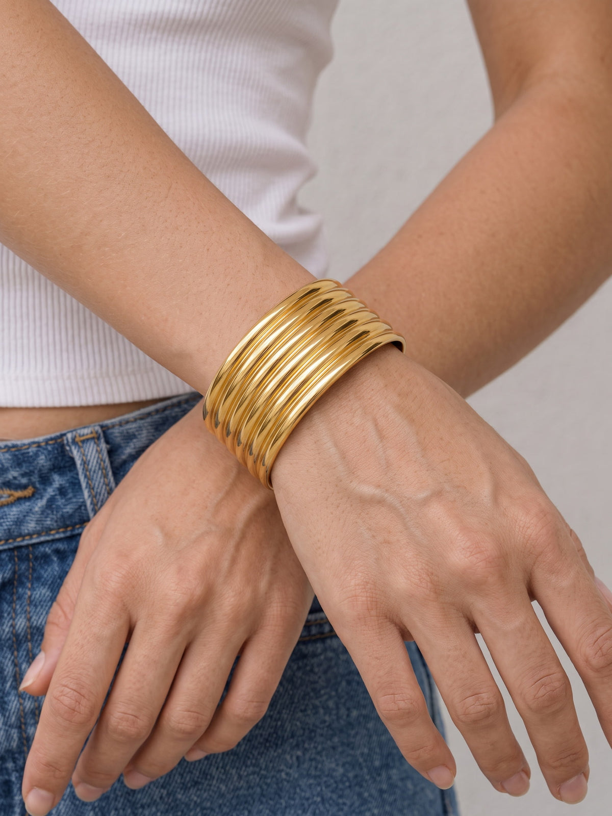 Gold Aurelia Ribbed Cuff styled on the wrist, highlighting the stacked-band look