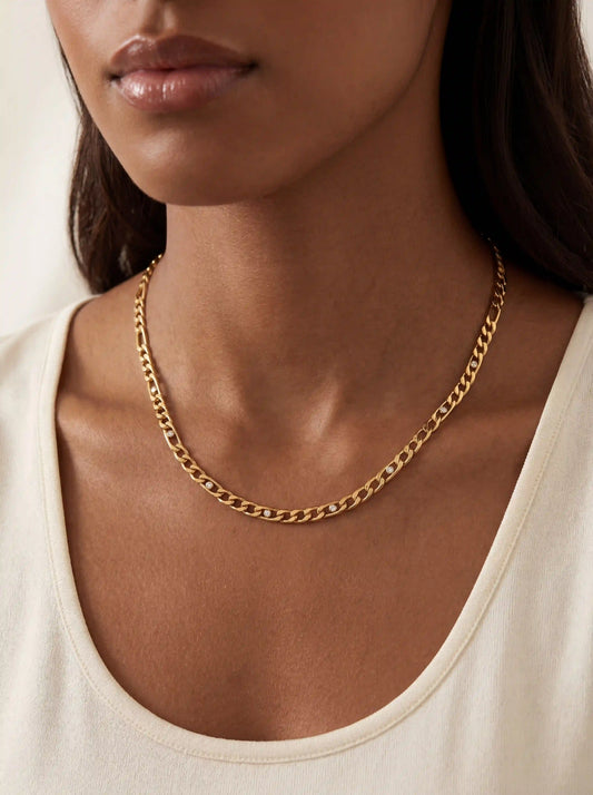 Close up of woman with dark skin wearing gold Aurelia curb chain necklace with pave crystal links.