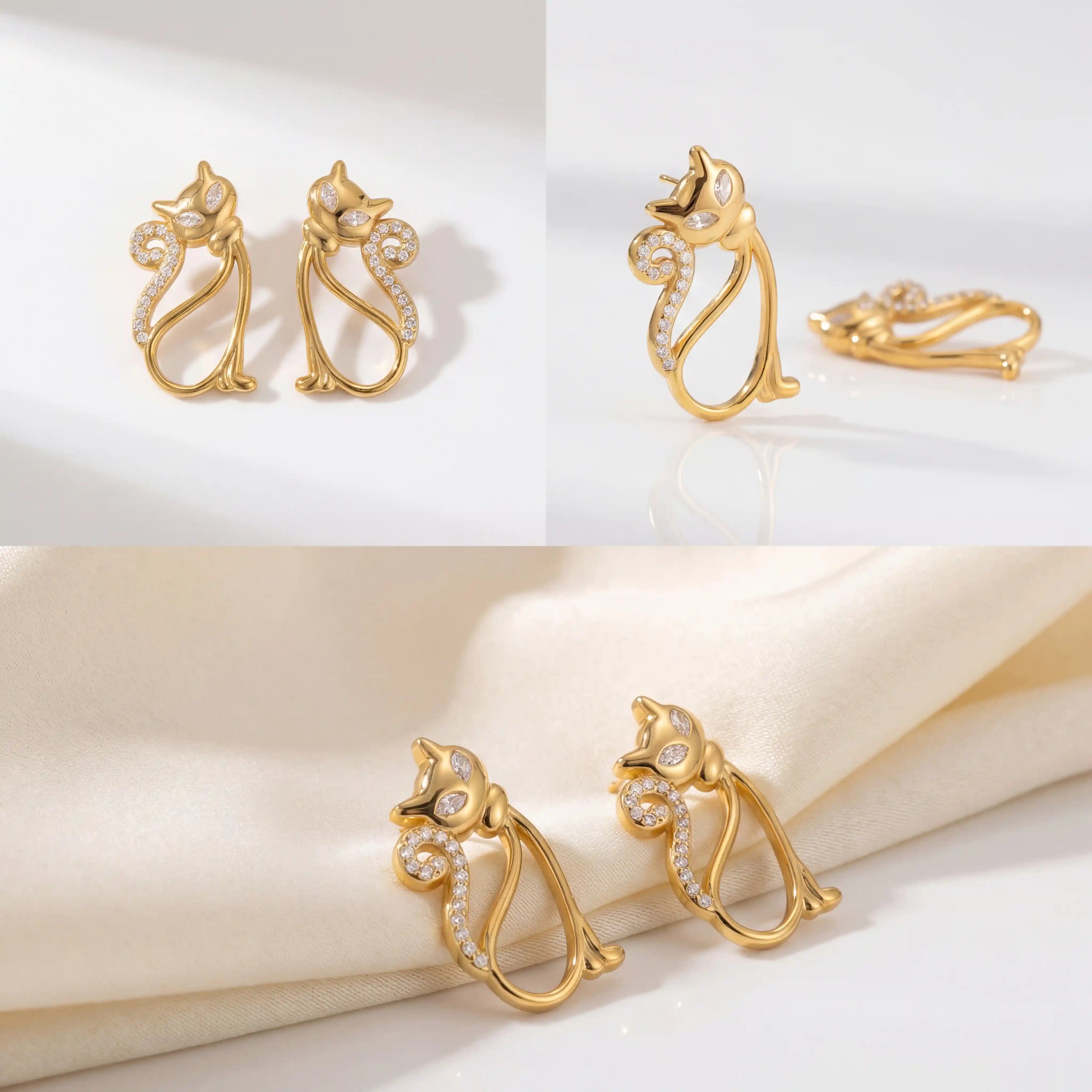 Aesthetic product photography of gold crystal cat earrings on white silk background.