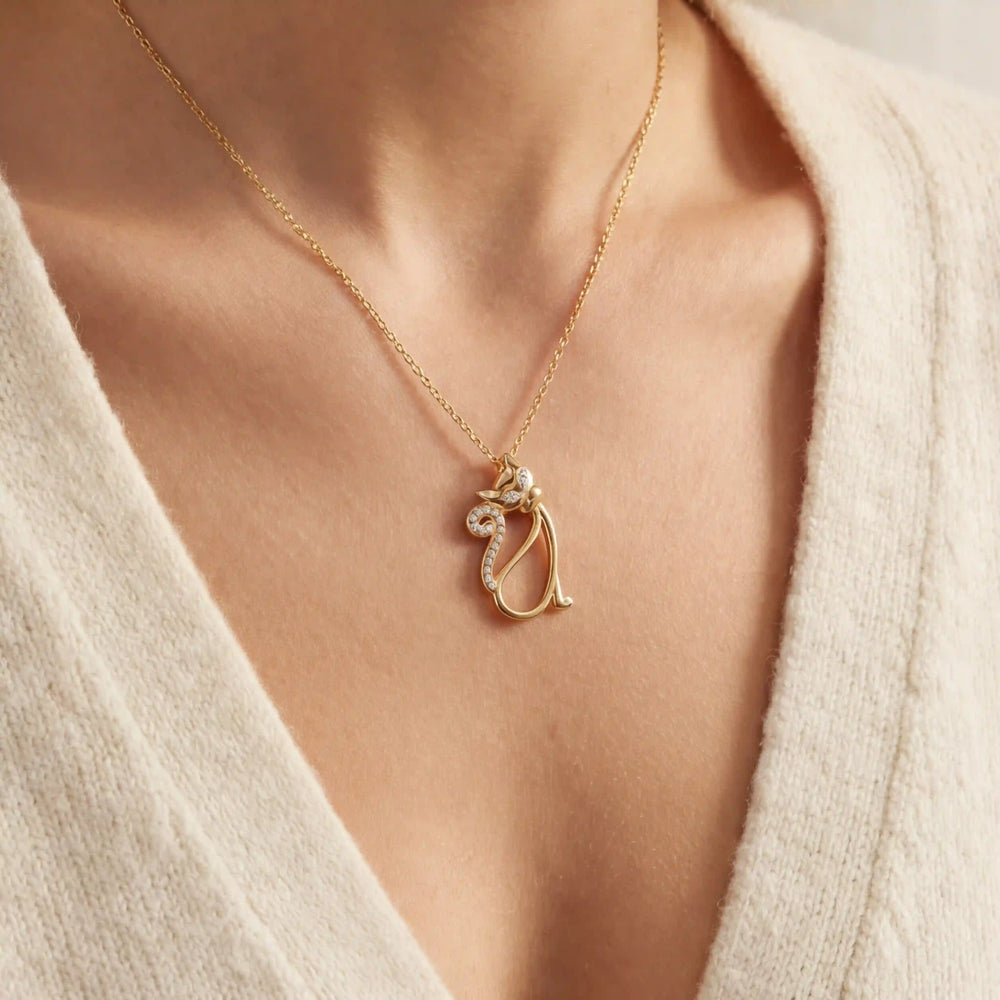 Close up of woman wearing gold Bastet crystal cat pendant necklace whimsical animal jewelry.