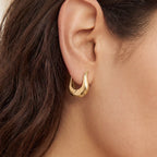 Close up of woman wearing gold Calla sculptural U-hoops modern minimalist jewelry.