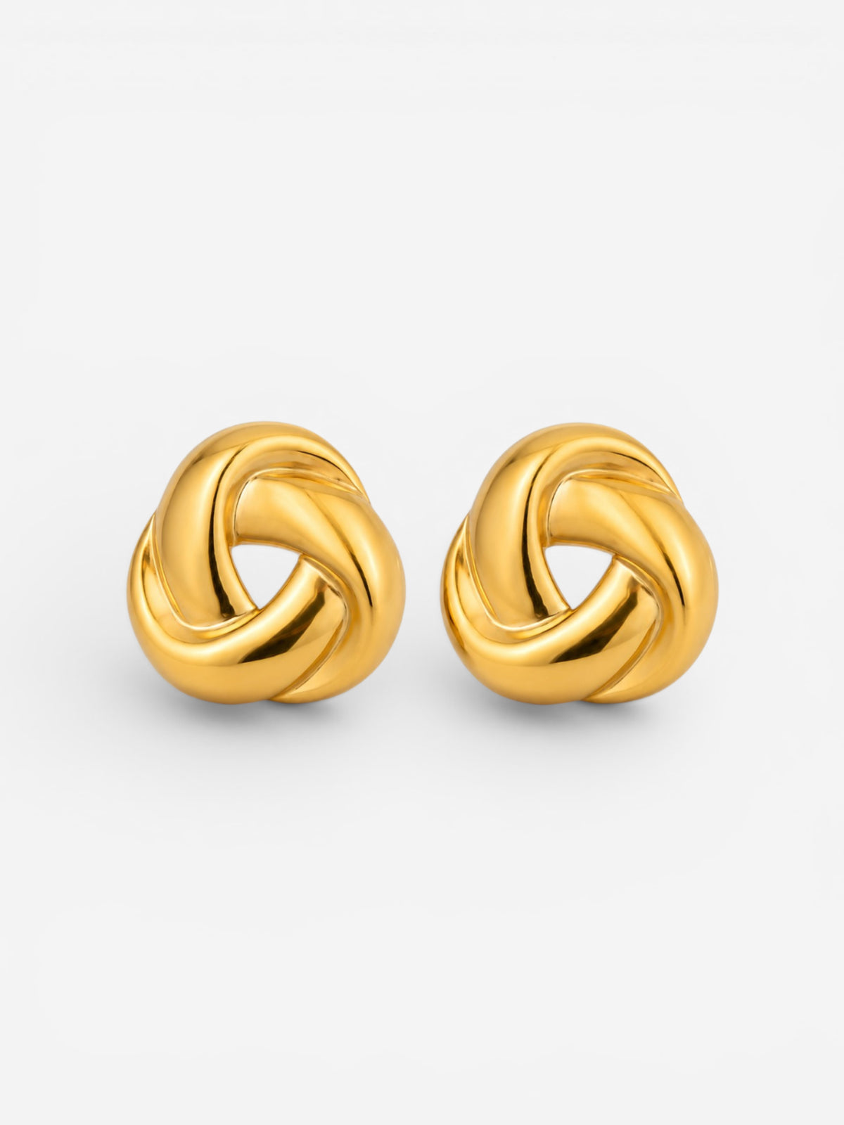 Pair of polished gold chunky knot stud earrings on a light background
