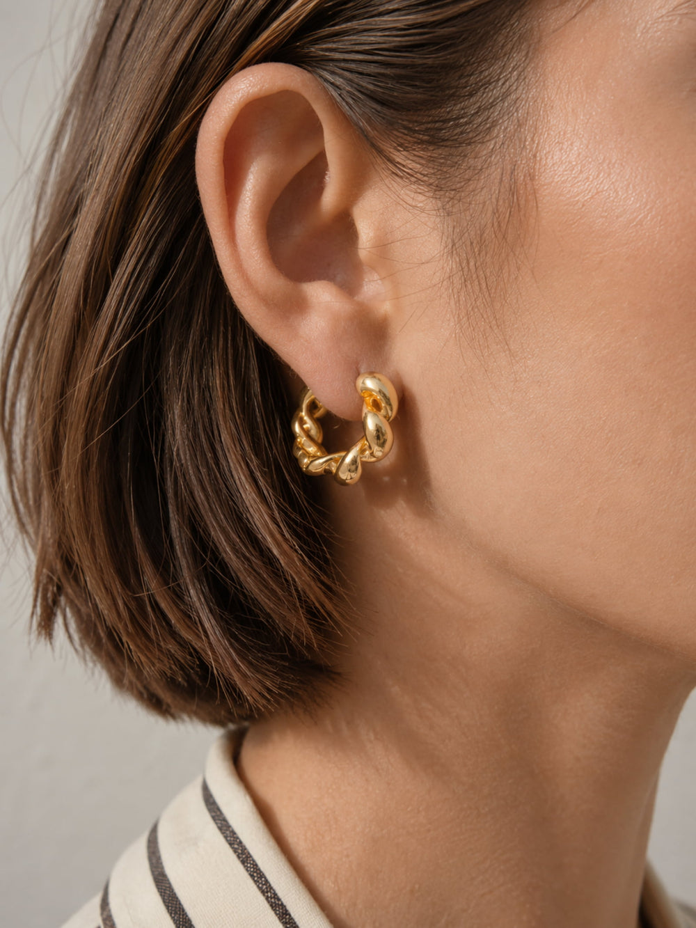 Model wearing Chunky Twisted Gold Hoop Earrings with a simple everyday outfit