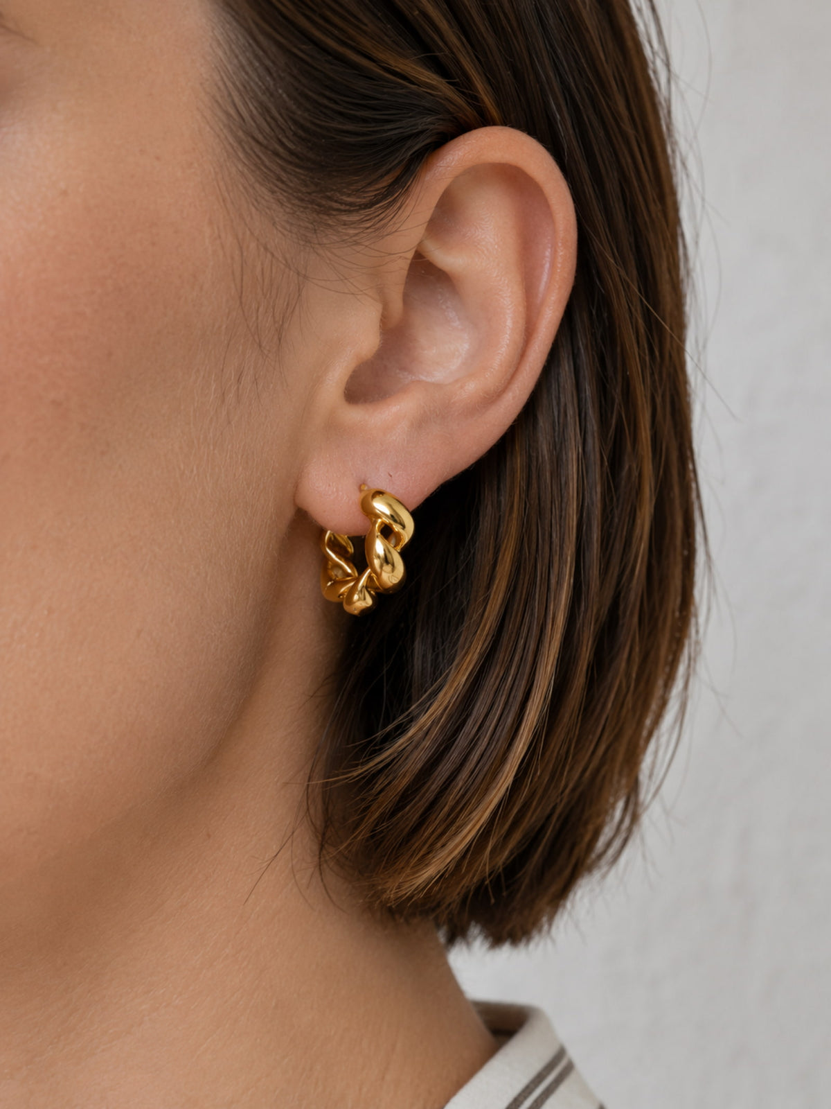 Model wearing Chunky Twisted Gold Hoop Earrings with a simple everyday outfit